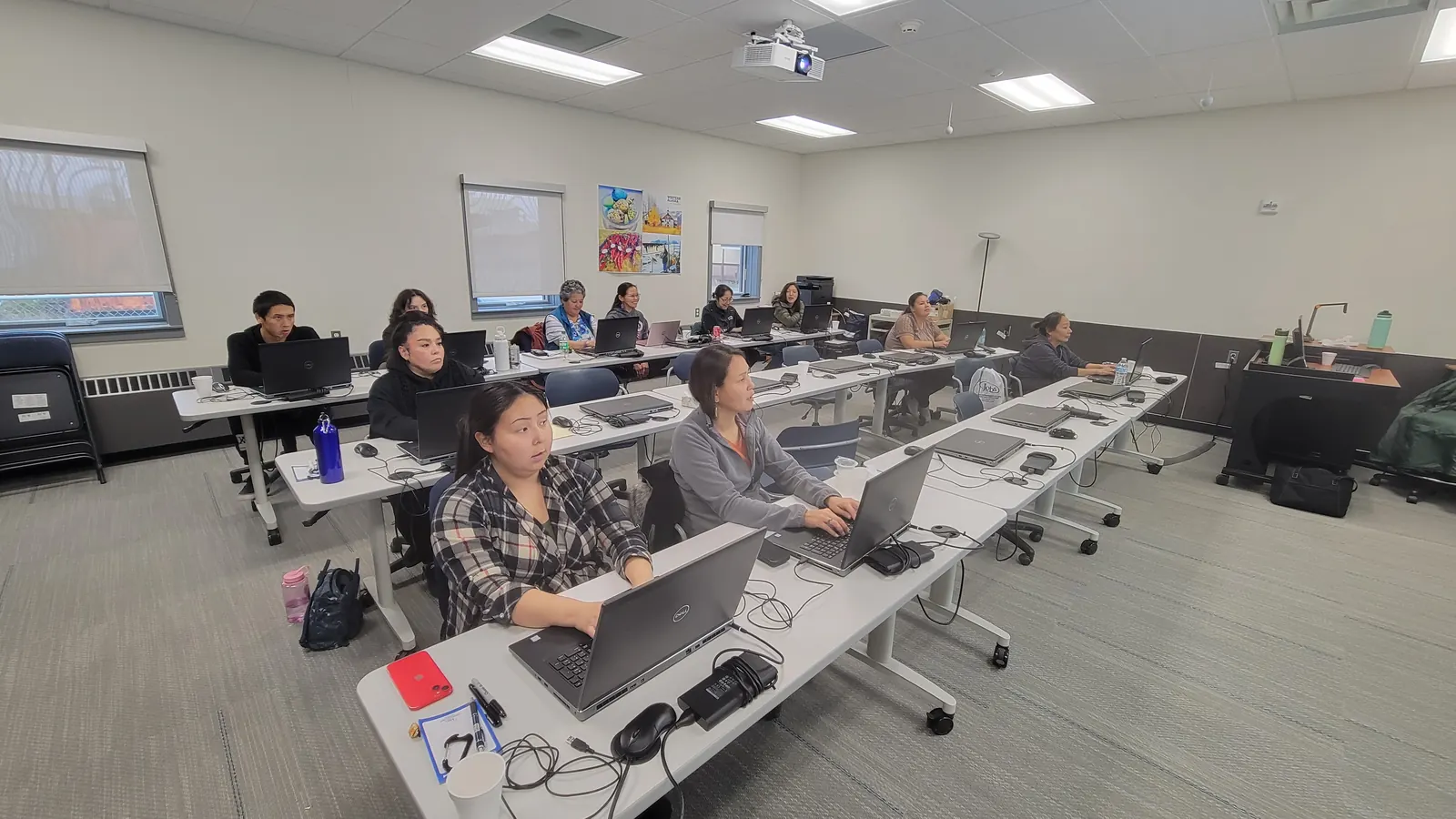 Participants working at laptops in a training session