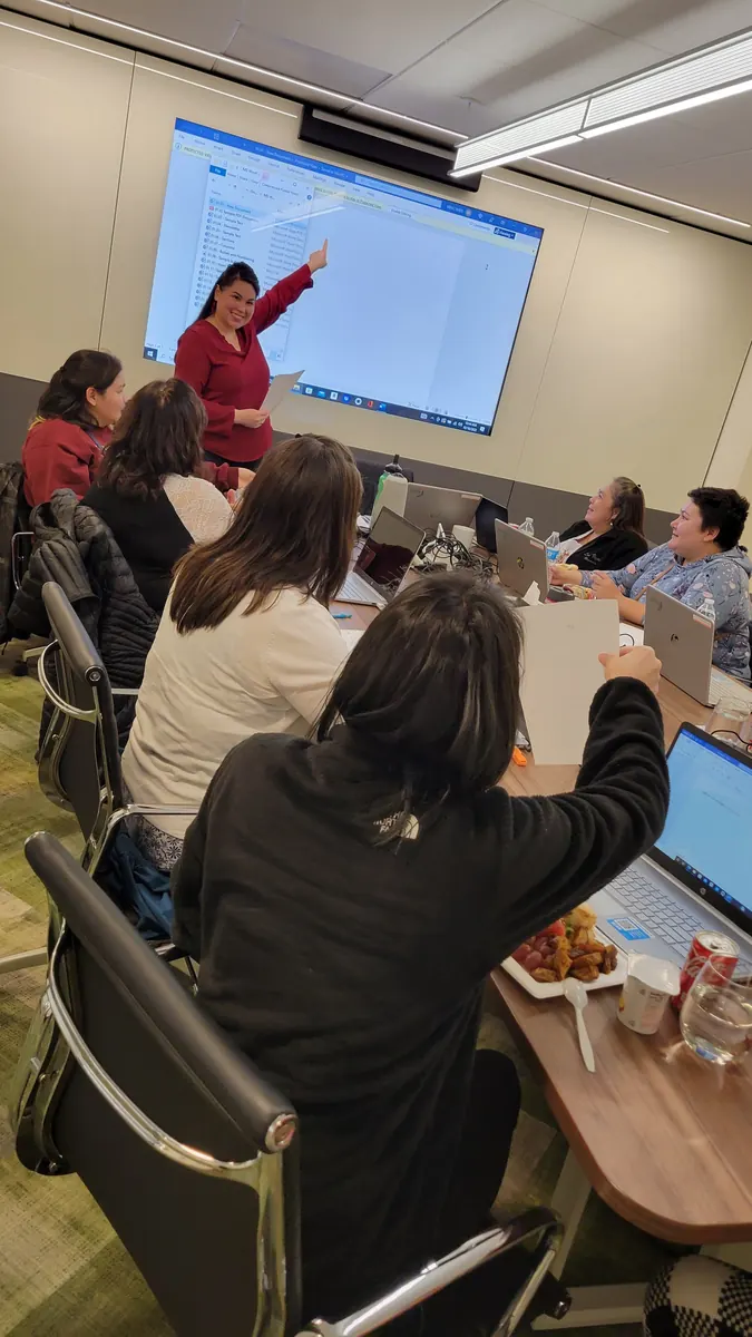 Yvonne facilitating a training session with participants seated around tables